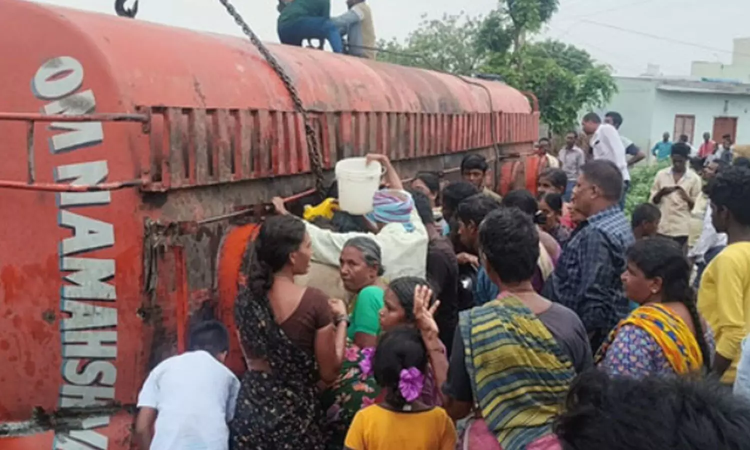 రోడ్డుపై బోల్తా కొట్టిన పామాయిల్ ట్యాంకర్.. ఎగబడిన జనం