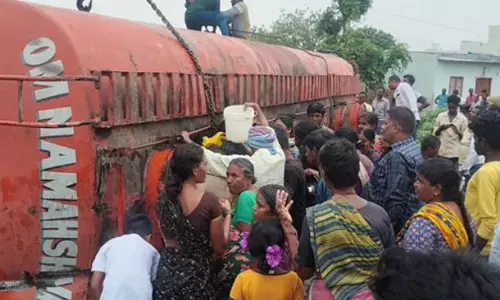 రోడ్డుపై బోల్తా కొట్టిన పామాయిల్ ట్యాంకర్.. ఎగబడిన జనం