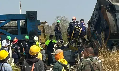 Rescue workers near derailed passenger train after crane collapse in Nakhon Ratchasima, Thailand