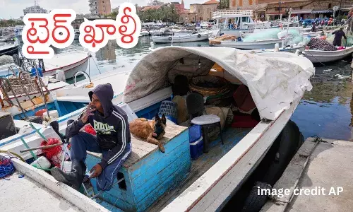 Ruins of apartment buildings in Tyre after Israeli airstrikes as residents remain despite evacuation orders.